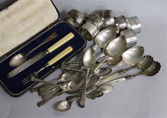 A cased matched 19th century silver christening trio, twenty ites of silver flatware and seven napkin rings including silver.